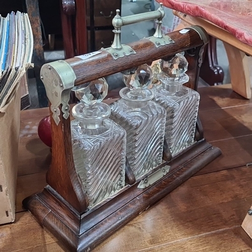 743 - Vintage Oak Tantalus with Three Cut Crystal Decanters. Features brass accents and intricate glass st... 