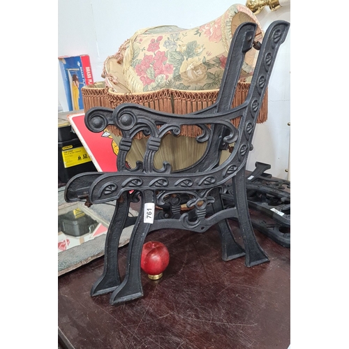 761 - A pair of vintage cast iron bench ends with decorative scrollwork detailing.