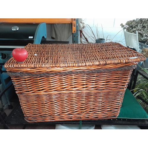 698 - A large wicker basket with hinged lid and rope handles.