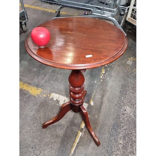 815 - A Victorian-style mahogany tripod wine table. Features Finely turned central column and cabriole fee... 