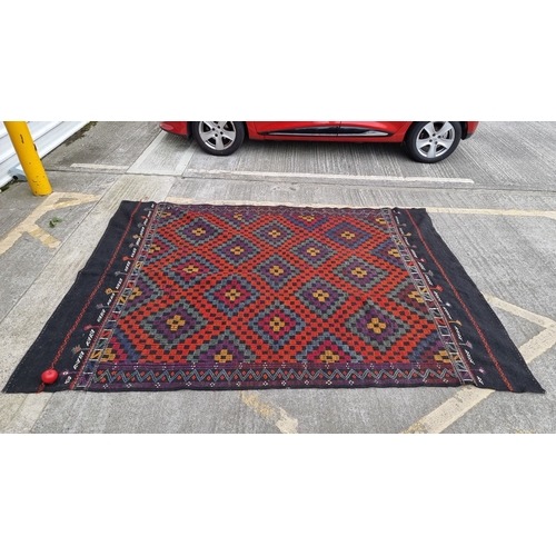 819 - Star lot : Handwoven Kilim rug featuring traditional geometric patterns in rich red, purple, and bla... 