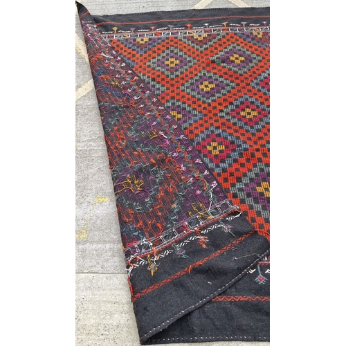 819 - Star lot : Handwoven Kilim rug featuring traditional geometric patterns in rich red, purple, and bla... 