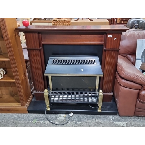 830 - Mahogany surround electric fireplace with brass accents and integrated controls.