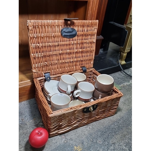 837 - Set of six Denby Stoneware cups and saucers in a wicker basket. Each cup and saucer features the sig... 