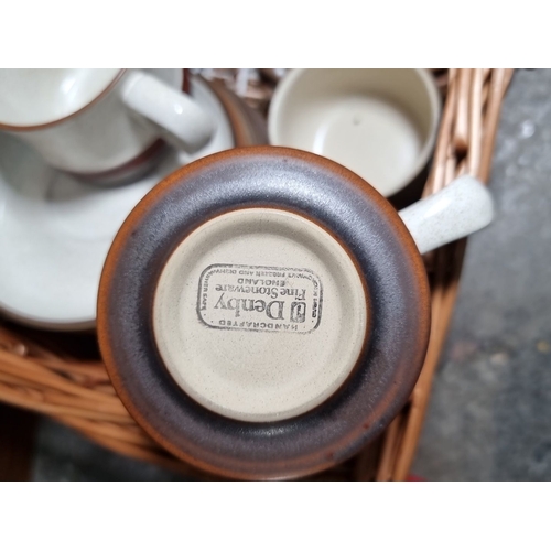 837 - Set of six Denby Stoneware cups and saucers in a wicker basket. Each cup and saucer features the sig... 