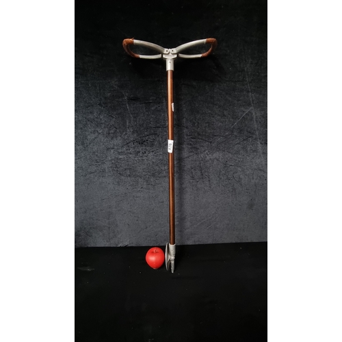 876 - An English made metal shooting stick with leather bound handles.