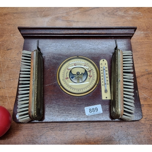 889 - A vintage wall hanging barometer with clothes brushes.