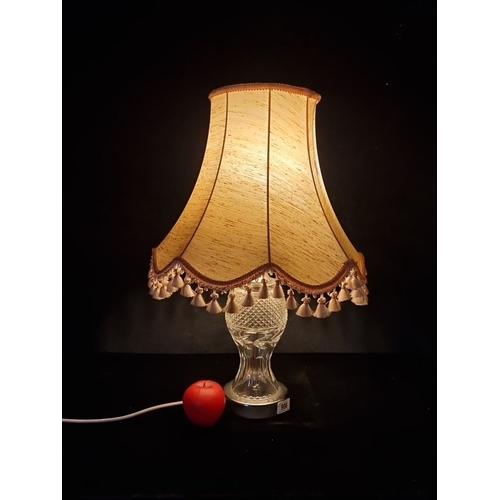 906 - An irish Crystal table lamp with a beige fabric shade adorned with tassels. Features a cut glass bas... 