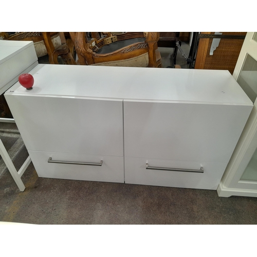 938 - A streamlined white gloss storage unit with two drawers to base and two cupboards, from the fabulous... 