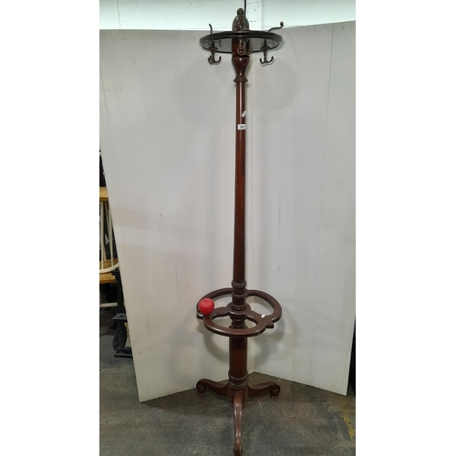 941 - An antique mahogany rotating coat rack / hat stand with original brass hooks