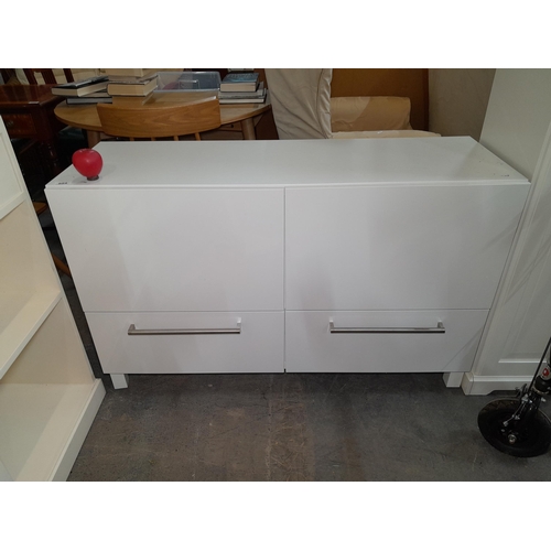 954 - A streamlined white gloss storage unit with two drawers to base and two cupboards, from a bedroom of... 