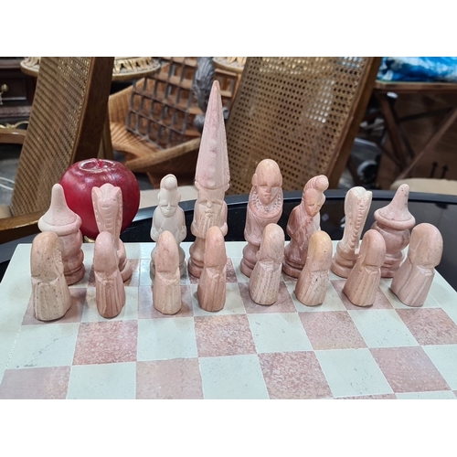 770 - A Hand-carved chess set made from stone. Includes intricately detailed pieces in shades of pink and ... 