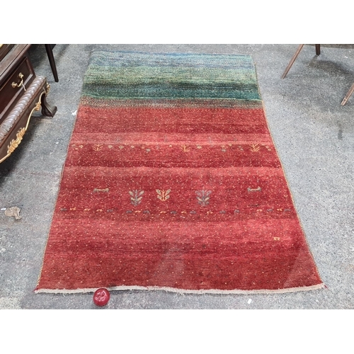 783 - Star lot : Handwoven wool rug featuring a striking gradient design in red and green hues with intric... 