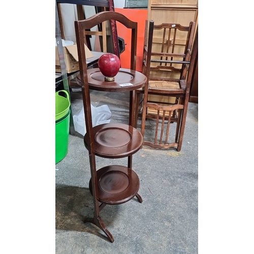 787 - Three-tier mahogany folding plant stand, likely early 20th century, featuring round plate shelves an... 