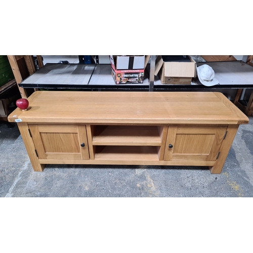 789 - Solid oak TV stand with two cabinets and central shelving. Black knob handles and a smooth, polished... 