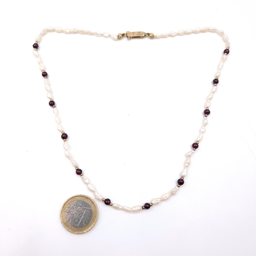 1015 - A very pretty Pearl and Garnet choker necklace with 9ct Gold catch. Marks indistinct. Boxed.
Total L... 