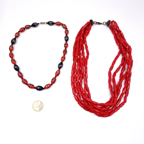 1031 - Two eye catching red coral necklaces. Including a red and black beaded example. Along with a multi l... 