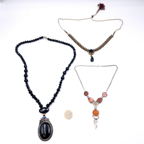 1033 - Three necklaces including a long black beaded example with an 'Onex' pendant.