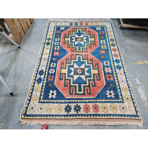 945 - Star lot : A beautiful hand made Persian rug featuring geometric patterns in tone of blue, orange, y... 