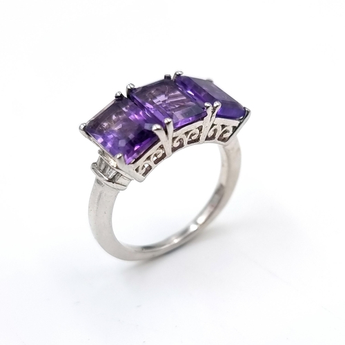 34 - A very good example of a three stone amethyst ring set with diamond accents mounted in sterling silv... 