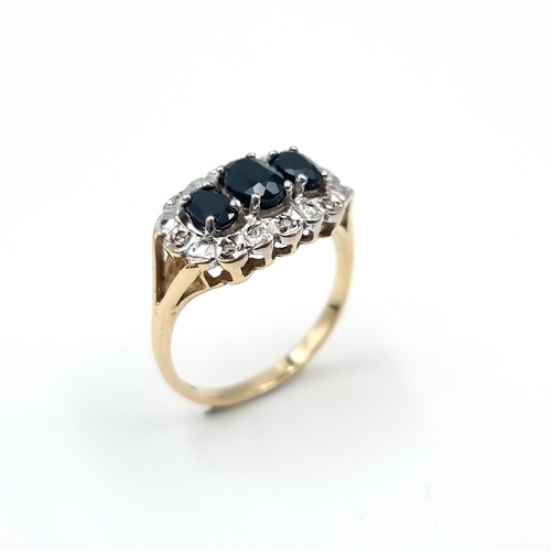 4 - Star lot : A most attractive three stone sapphire ring with diamond surround mounted in nine carat g... 