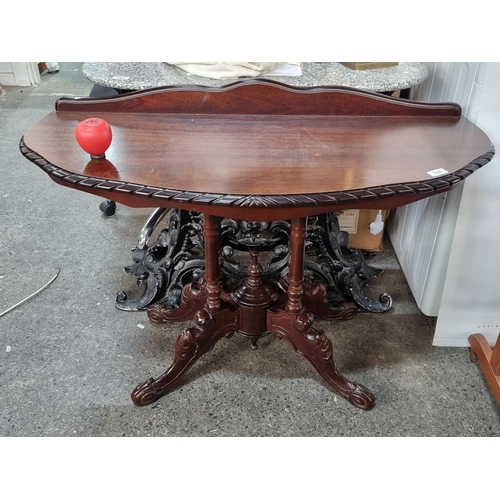 780 - A beautiful solid mahogany table featuring gallery back, cabriole legs and wristed supports.