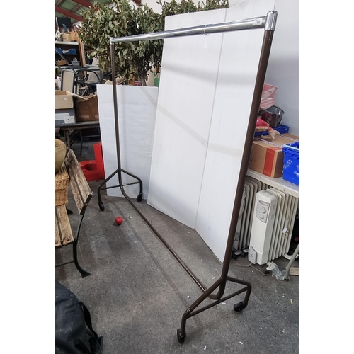 790 - A large metal clothing rail set on castor wheels, ideal for shop display.