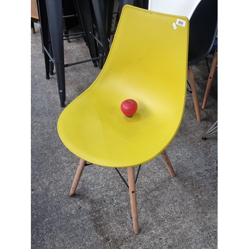 800 - A trendy yellow chair with wooden legs and metal stretchers.