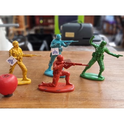 A set of four colorful cast metal solider action figures in the colours of blue, green, mustard and red. Unused and still in original packaging