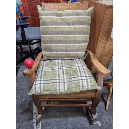 841 - A lovey wooden slatted back rocking chair along with two plump green plaid patterned cushions