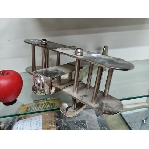 964 - A silver-plated airplane figurine. Features detailed craftsmanship with twin wings and a streamlined... 