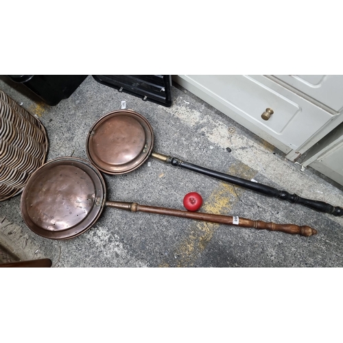 968 - A pair of antique copper bed warmers with turned wood handles, showcasing a traditional design. Like... 