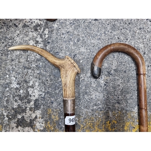 969 - Two antique walking sticks. One has a curved wooden handle and a silver tip while the other features... 