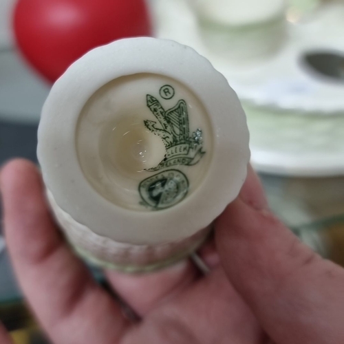 975 - A porcelain egg cup set from Belleek Ireland. Set on a circular stand and decorated with a delicate ... 