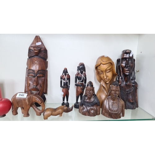 946 - Eight carved wooden figurines featuring various traditional African designs. The collection includes... 