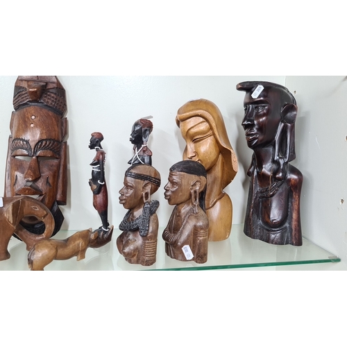 946 - Eight carved wooden figurines featuring various traditional African designs. The collection includes... 