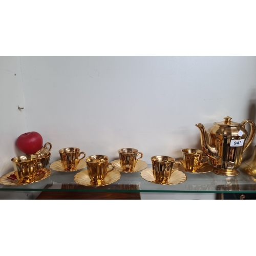 947 - A gold-tone six-piece tea set from Wade England, comprising a teapot, six cups, and saucers. Showcas... 