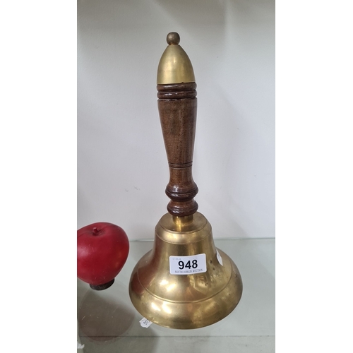 948 - An antique brass hand bell with turned wood handle, likely  early 20th century. The inside is marked... 