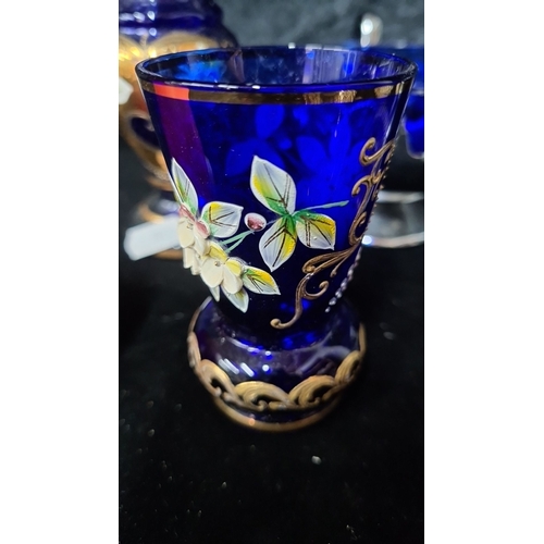 984 - A collection of nine pieces, featuring cobalt blue glass decor with floral enamel details and clear ... 