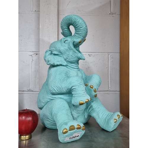 1004 - An Aqua blue elephant figurine with gold accents on the toes and trunk.