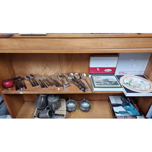 1010 - A mixed lot of cutlery, including forks, knives, and various spoons. Also includes boxed placemats a... 