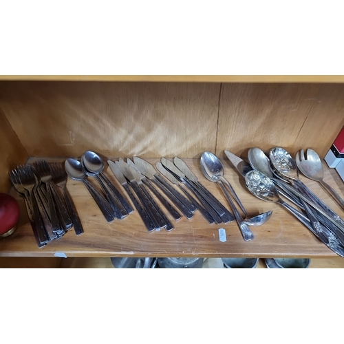 1010 - A mixed lot of cutlery, including forks, knives, and various spoons. Also includes boxed placemats a... 