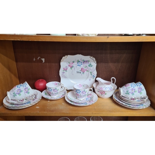 1016 - A fine English Bone China tea set, made in England. Includes teacups, saucers, plates, creamer, and ... 