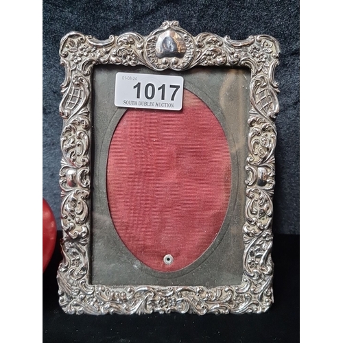 1017 - An ornate antique sterling silver picture frame with intricate floral and scrollwork design, featuri... 