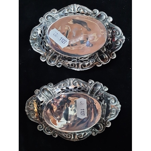 1019 - A pair of intricately designed sterling silver dishes with ornate filigree and scroll work detailing... 