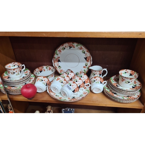 1020 - A tea set by Windsor China from Hill & Co., featuring intricate floral patterns. The set includes cu... 