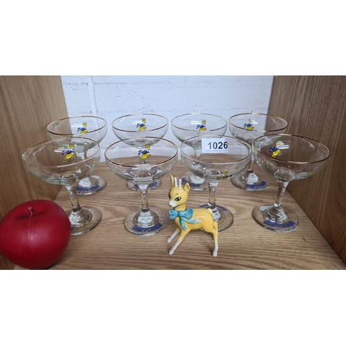 1026 - An excellent set of eight Babycham champagne coup glasses with gold rims. Includes a Babycham deer f... 