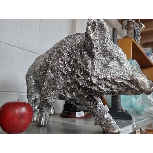 987 - A silver-toned wild boar statue, intricately detailed, measuring approximately 18 inches in length.