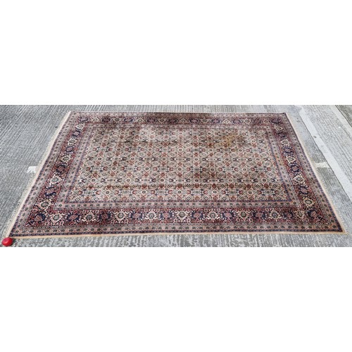 842 - Star Lot : A wonderful large Persian style wool rug in rich tones of dark blue, cream, red and dark ... 