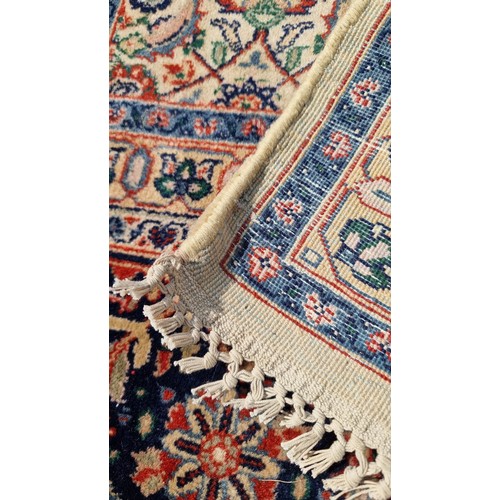 842 - Star Lot : A wonderful large Persian style wool rug in rich tones of dark blue, cream, red and dark ... 